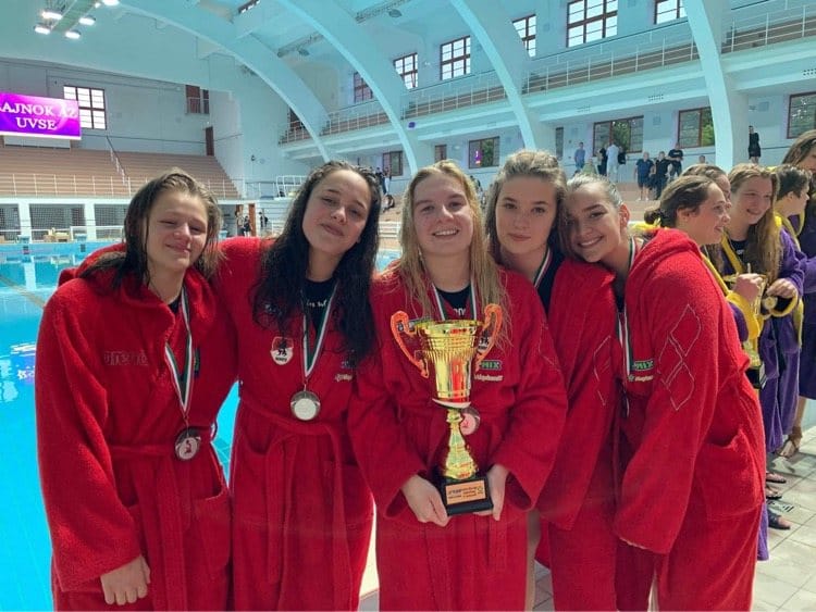 POLO Sport Club vízilabdázói kupával és érmekkel a medence mellett